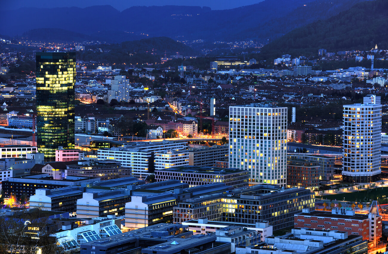 Abendliche Skyline von Zürich mit Prime Tower und modernen Hochhäusern im Quartier Zürich-West – Symbol für städtisches Wachstum, Urbanisierung und steigende Wohnraumnachfrage durch das Bevölkerungswachstum.